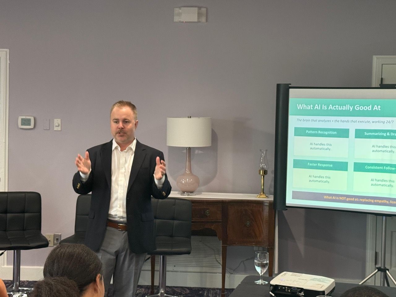 Jonathan Ferrell teaching an in-person workshop beside a presentation titled What AI Is Actually Good At.